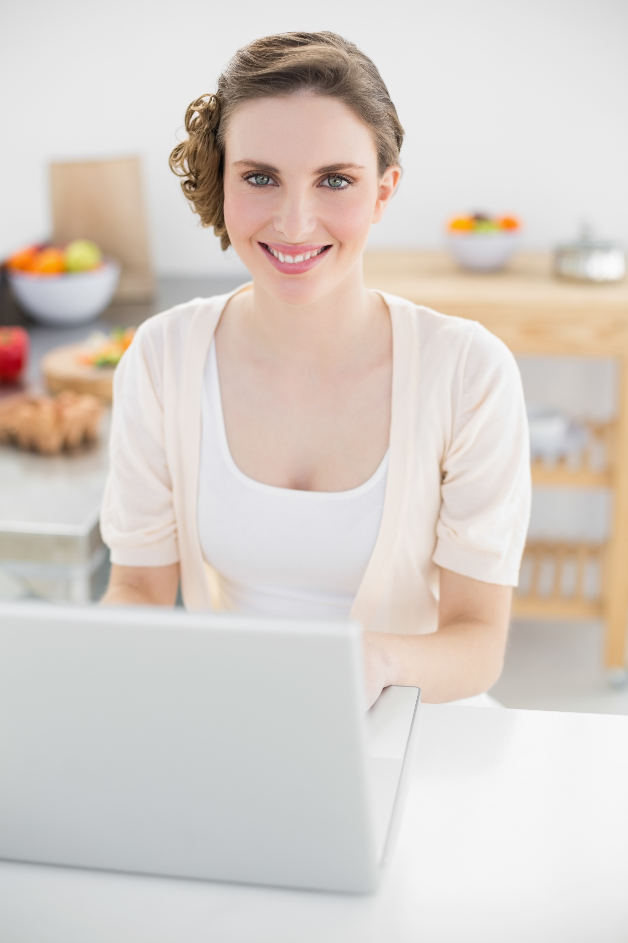 Instructor smiling with laptop in kitchen